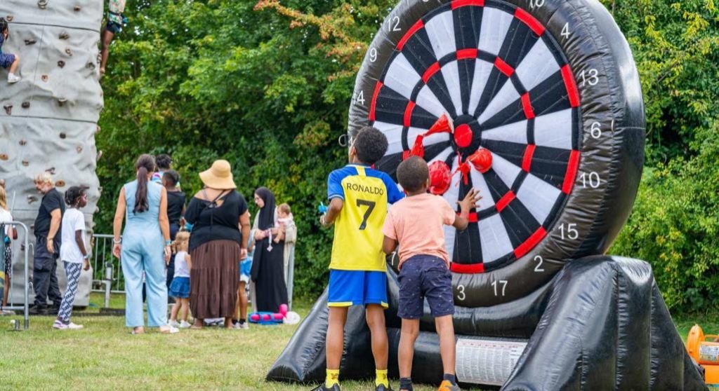 Children playing inflatable football darts at Summer Fun 2025